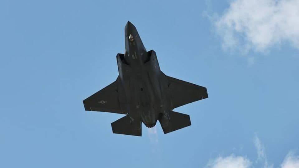 Mavi gökyüzünde uçan bir F-35 savaş uçağı.