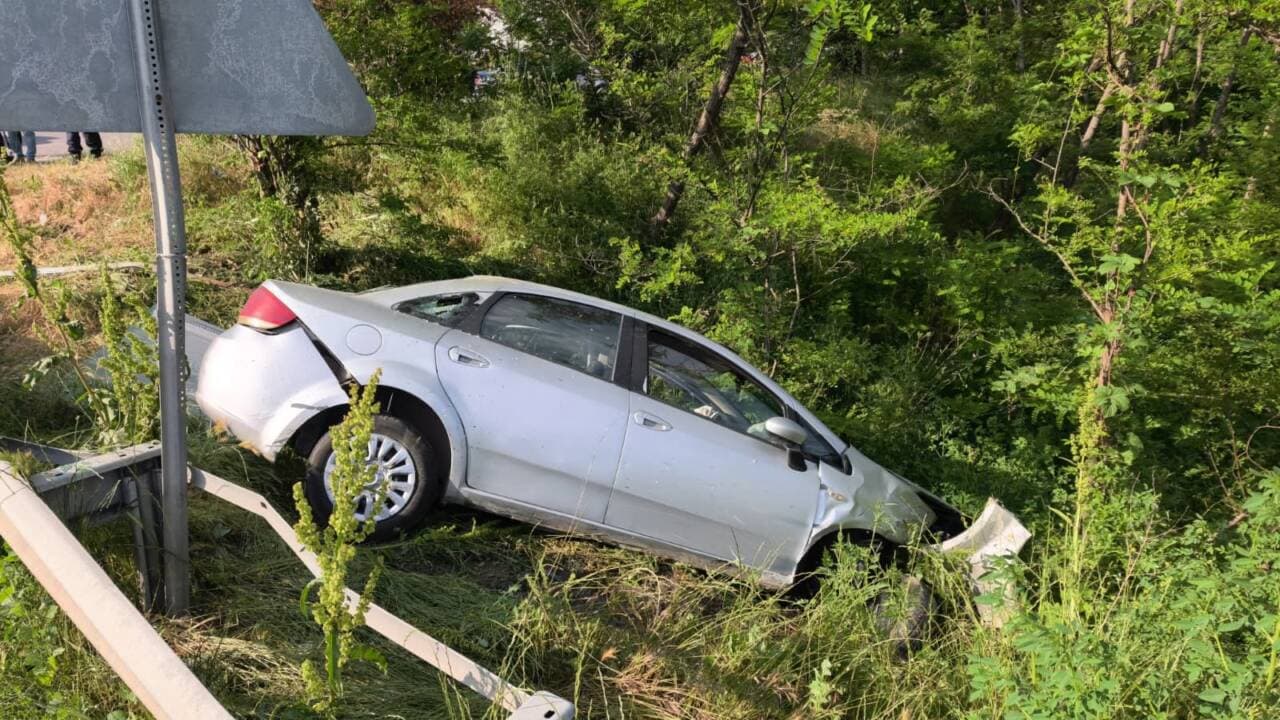 Bursa-Ankara Karayolu'nda bariyerlere çarparak şarampole devrilen hasarlı otomobil.