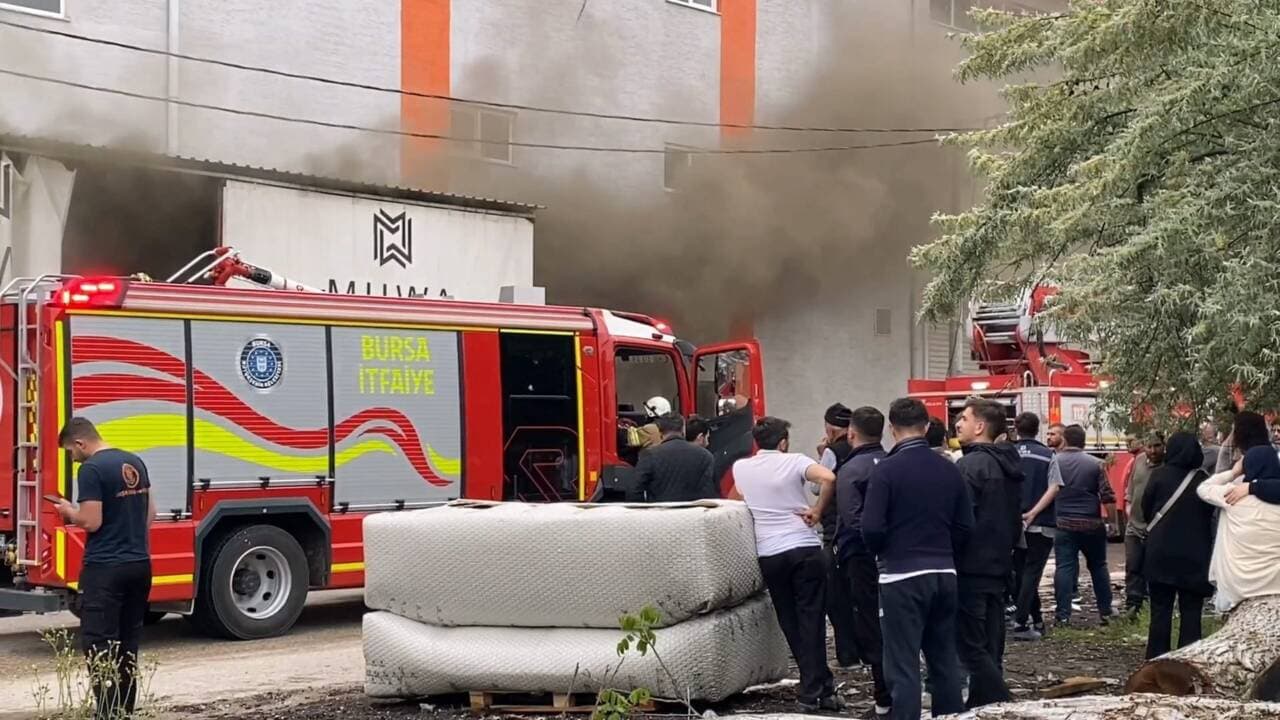 Bursa İnegöl'de yanan koltuk fabrikasına müdahale eden itfaiye ekipleri ve dumanlar.