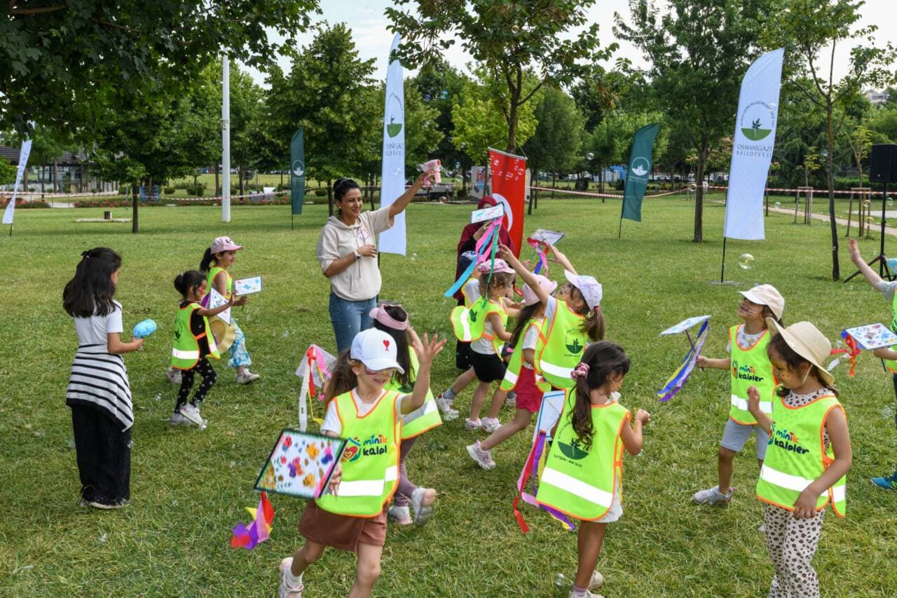 Osmangazi'de düzenlenen 'Yaza Merhaba' etkinliğinde parkta eğlenen çocuklar ve kursiyerler.