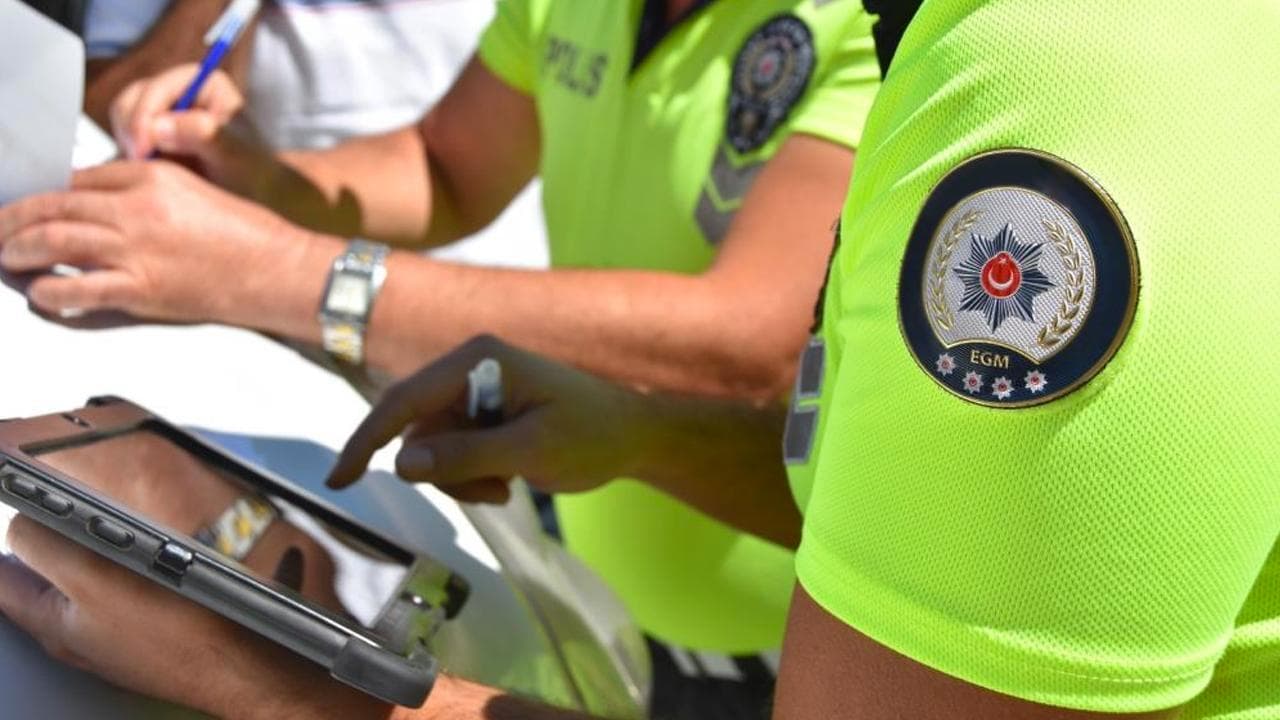 Trafik denetimi sırasında evrak işlemi yapan polis memurları.