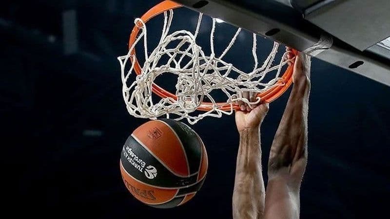 Basketbol potası, file ve smaç yapan bir oyuncunun elleri.
