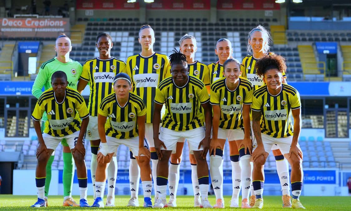 Fenerbahçe Kadın Futbol Takımı oyuncuları sahada toplu halde poz veriyor.