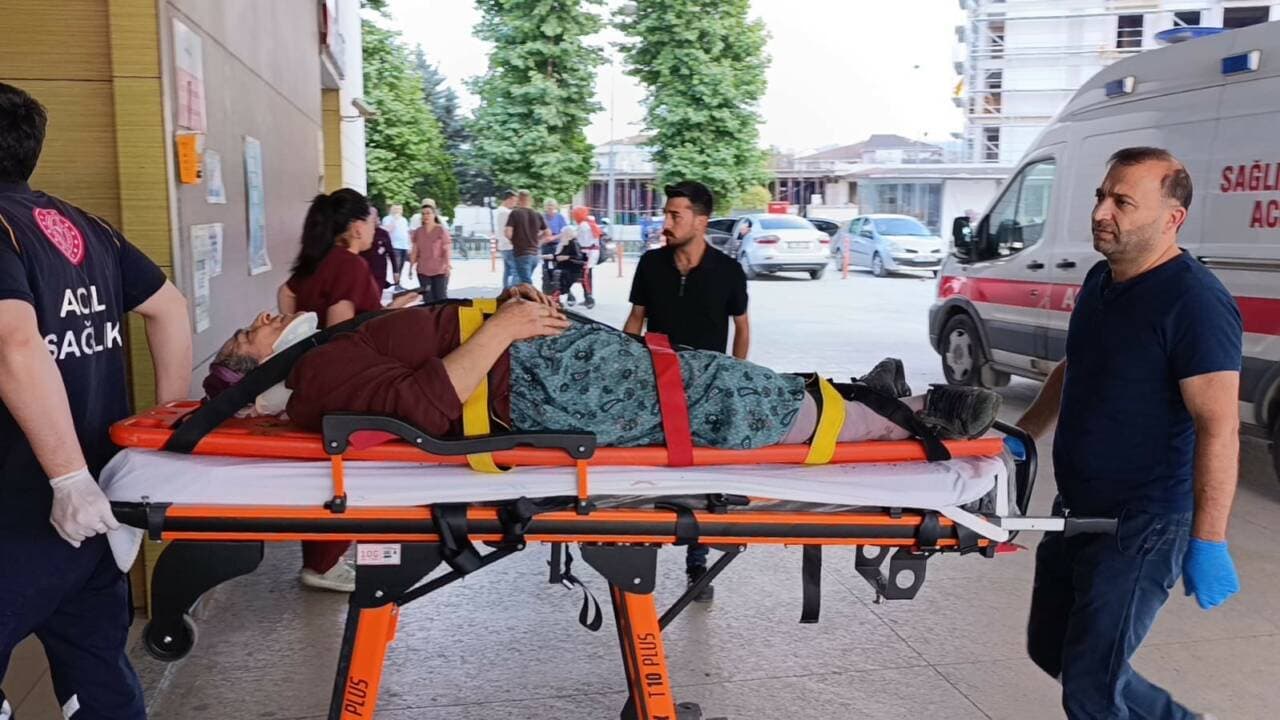 İnegöl'de kiraz toplarken düşen yaralı kadın sedyede, sağlık ekipleri tarafından taşınıyor.