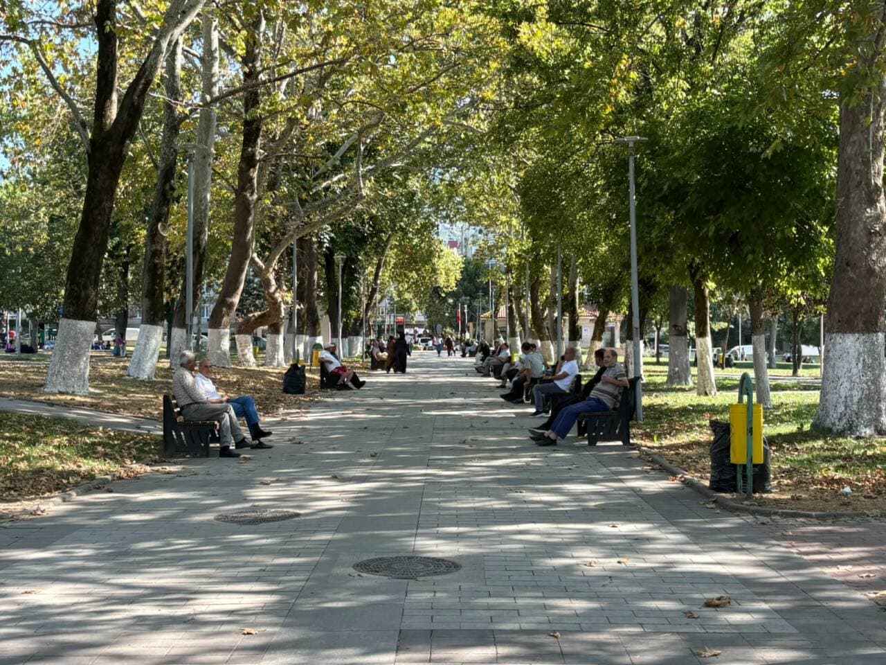 Bursa'da sıcak havada parkta gölgelik alanda oturan insanlar