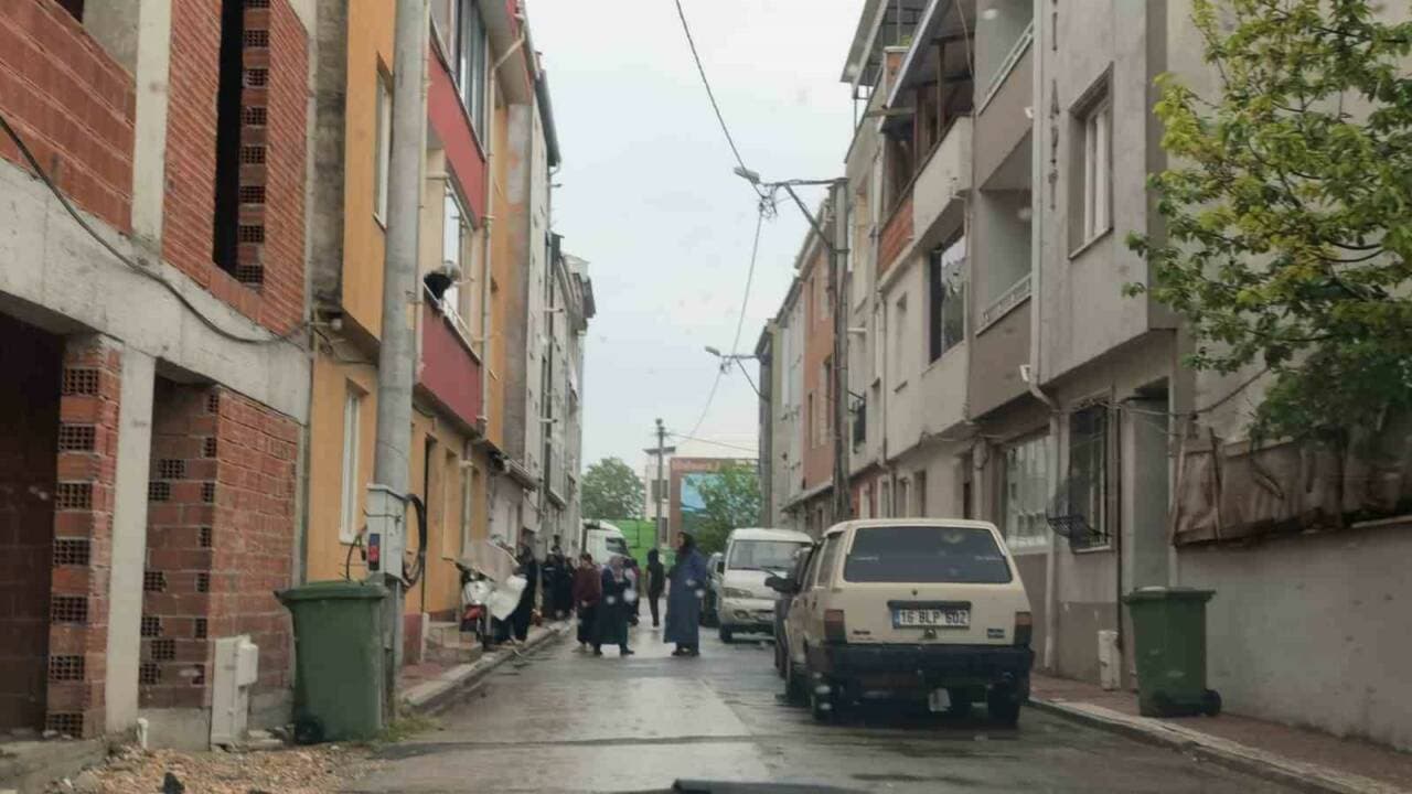 İnegöl'de balkondan düşme olayının yaşandığı sokak ve olay yerindeki vatandaşlar.