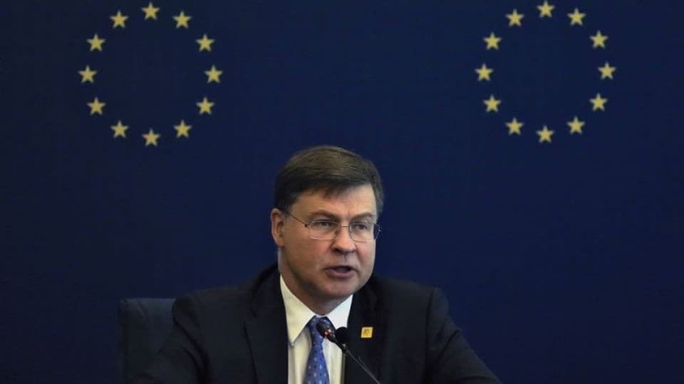 AB Ekonomi Komiseri Valdis Dombrovskis, AB bayrağı önünde konuşma yapıyor.