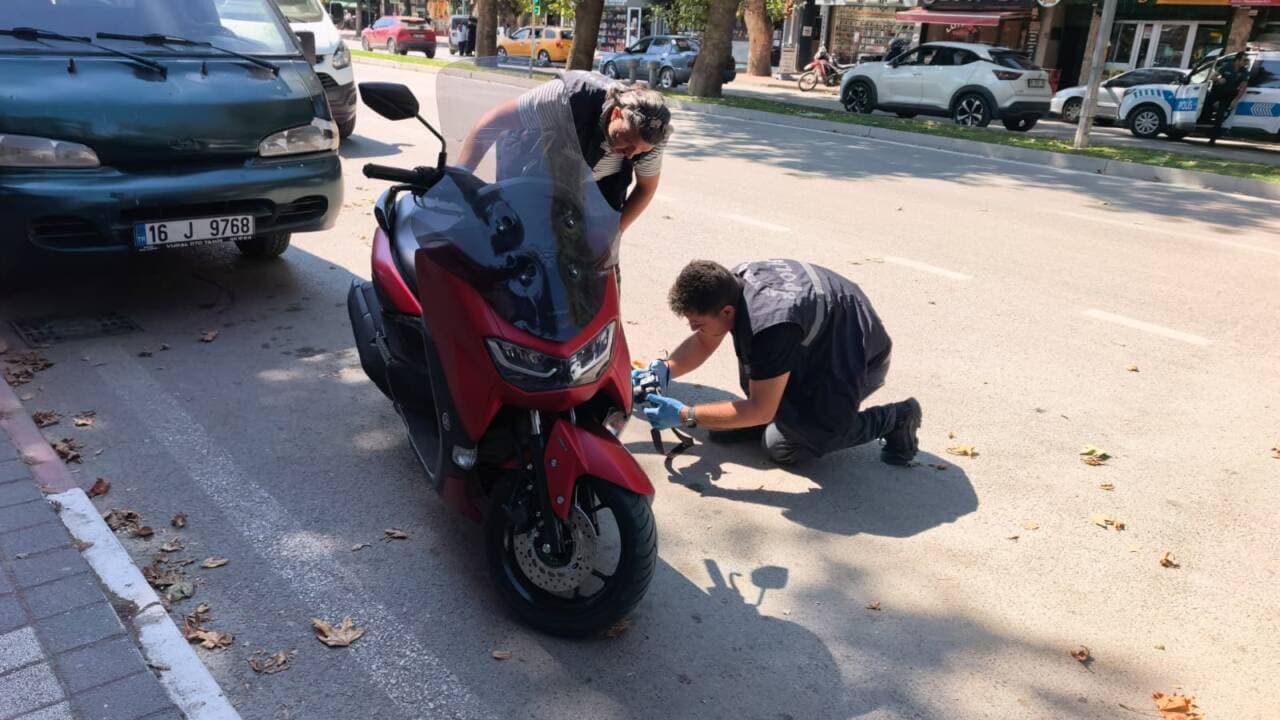 Bursa'da sahte plaka denetimi yapan trafik polisi ve motosiklet.