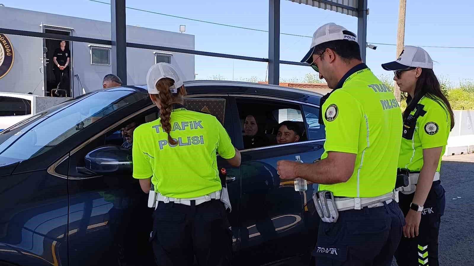 Tekirdağ'da trafik polisleri, Kurban Bayramı denetimi sırasında bir araçtaki sürücü ve yolculara ikramda bulunuyor.