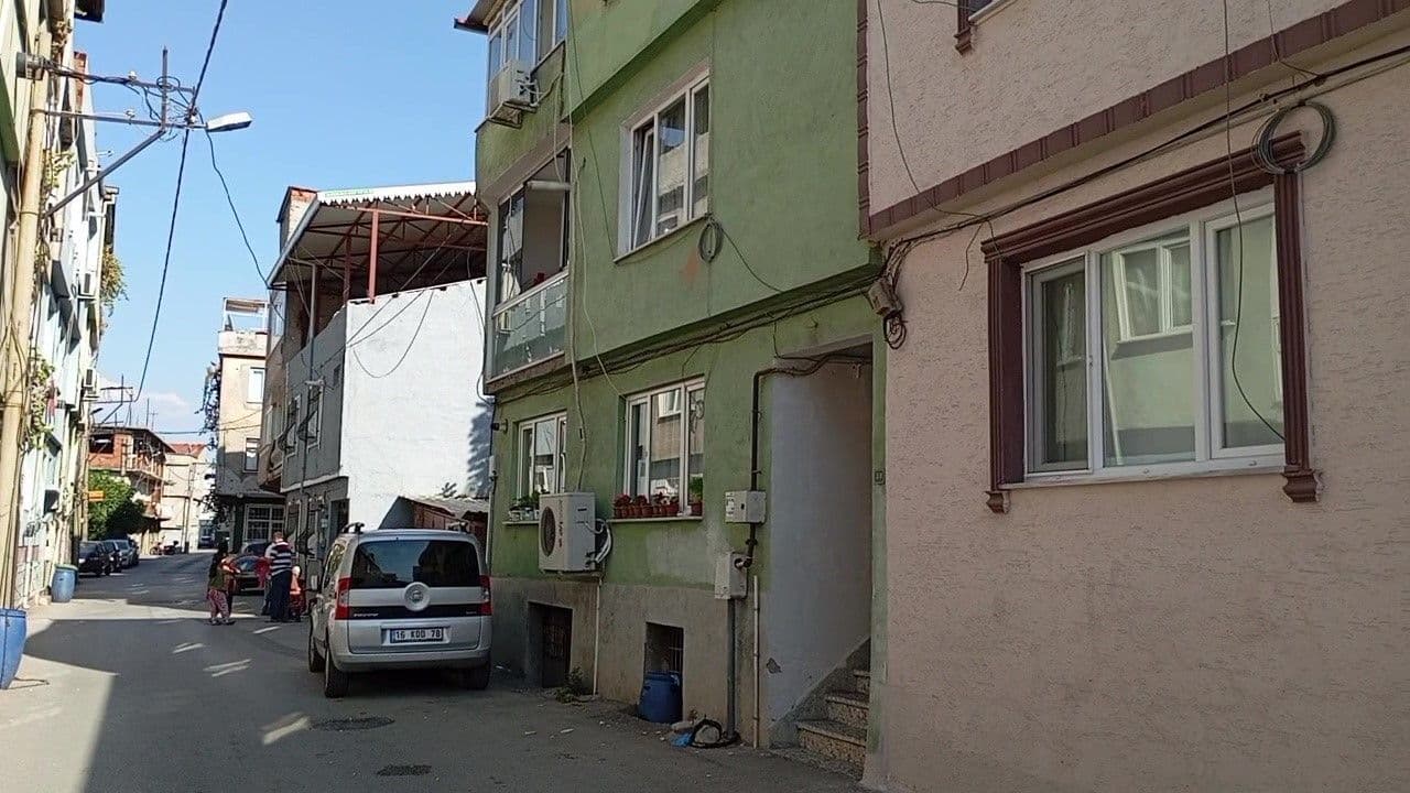 Bursa'da yaşlı çiftin ölü bulunduğu apartman dairesinin önünde polis ve itfaiye araçları.