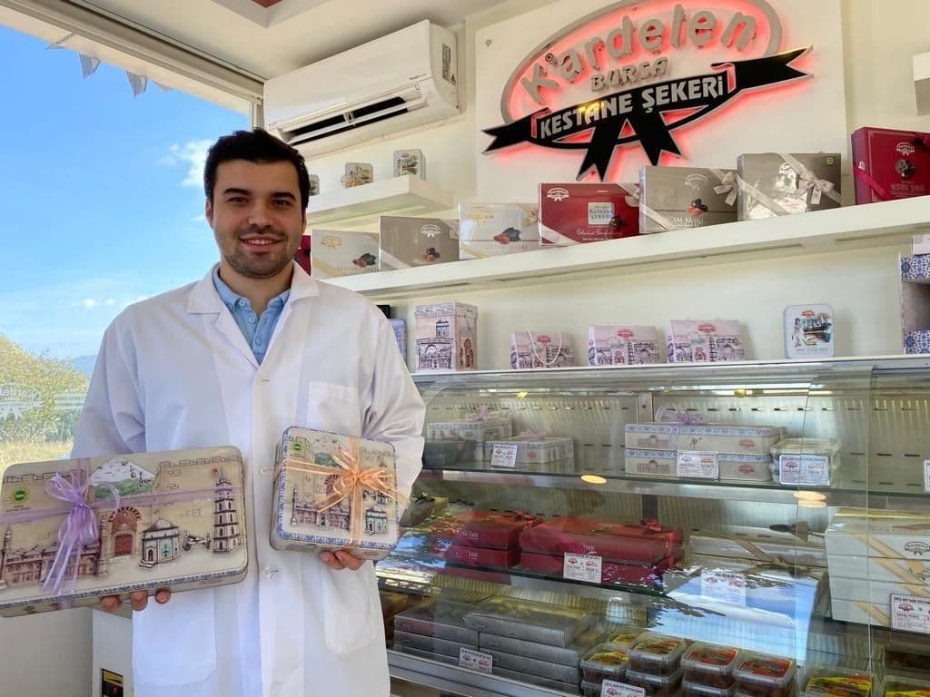 Kardelen Kestane Şekeri E-Ticaret Müdürü Tolga Akgün, bayramlık kestane şekeri kutularıyla.