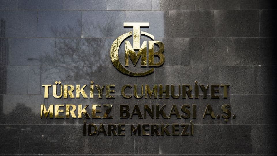 Türkiye Cumhuriyet Merkez Bankası (TCMB) binasının dış cephesindeki altın renkli logo ve yazı.