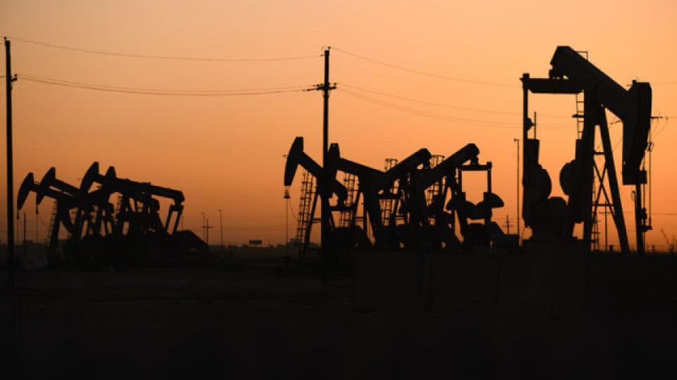 Gün batımında silüetleri görünen petrol pompaları.