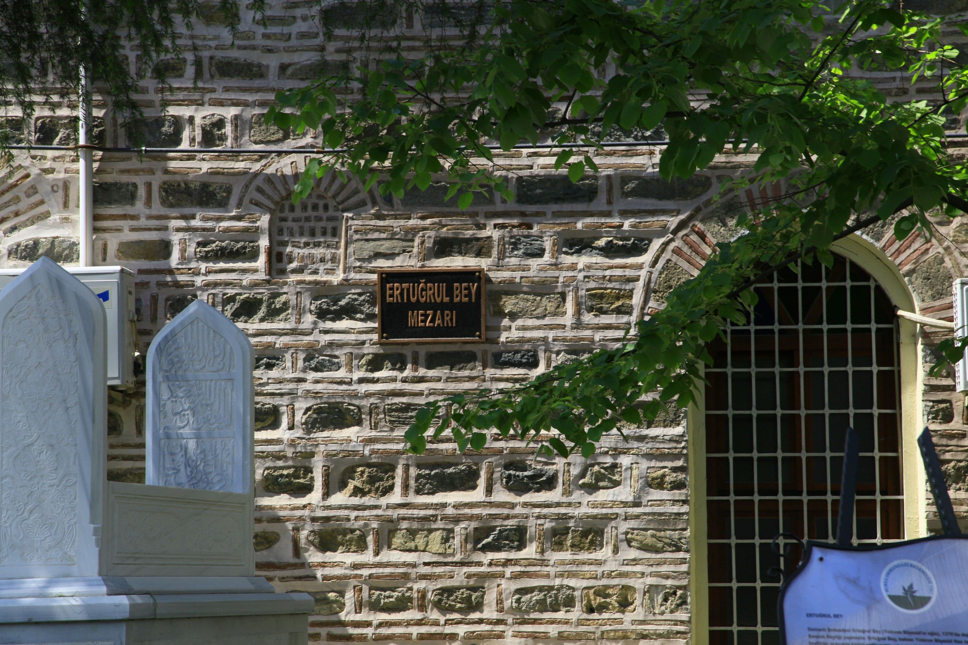 Ertuğrul Bey Mezarı tabelası ve tarihi taş duvar işçiliği.