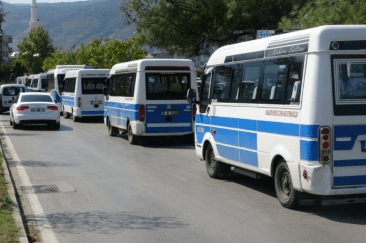 Bursa'da yolcu taşıyan, mavi beyaz renkli minibüsler yol kenarında sıralanmış.