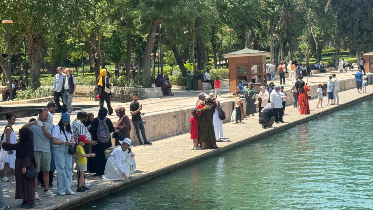 Şanlıurfa'da aşırı sıcaklardan bunalan vatandaşlar Balıklıgöl kenarında serinliyor.
