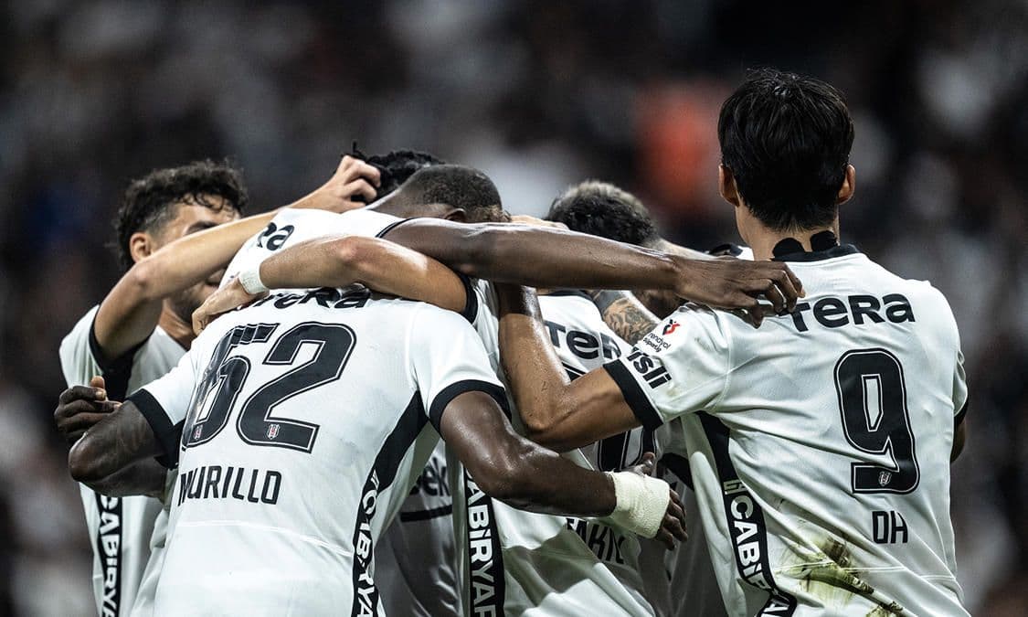 Beşiktaşlı futbolcular maç sonrası galibiyeti kutlarken, sahada birbirlerine sarılmış halde.