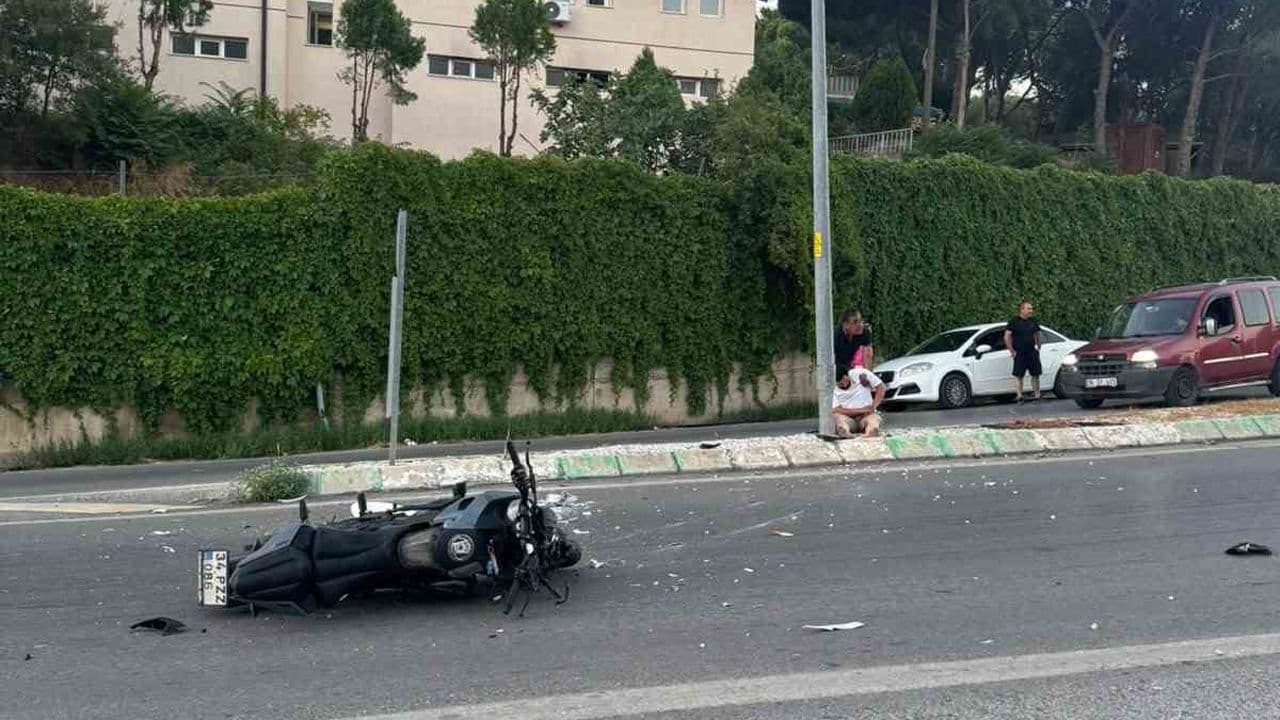 Bursa Gemlik'te motosiklet kazası sonrası yolda yatan motosiklet ve olay yerindeki kişiler.