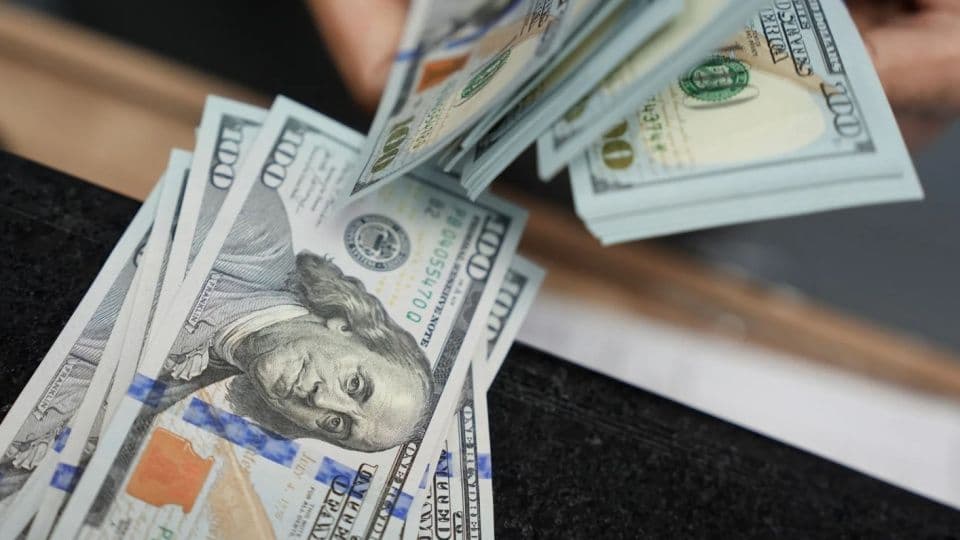 Bir masanın üzerinde duran 100 ABD doları banknotları.