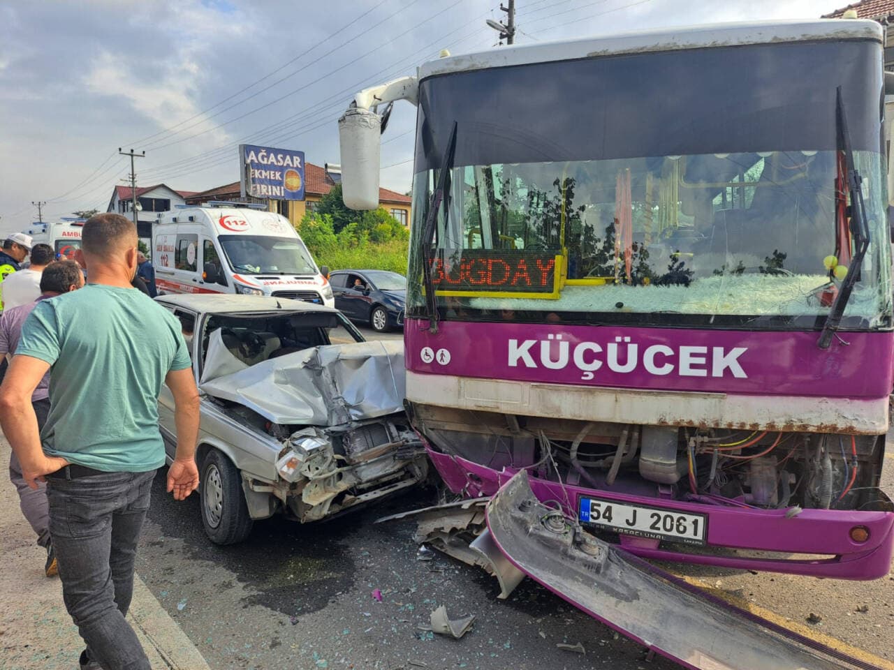 Sakarya Akyazı'da özel halk otobüsü ile otomobilin çarpıştığı trafik kazası, olay yerinde hasarlı araçlar ve ambulans.