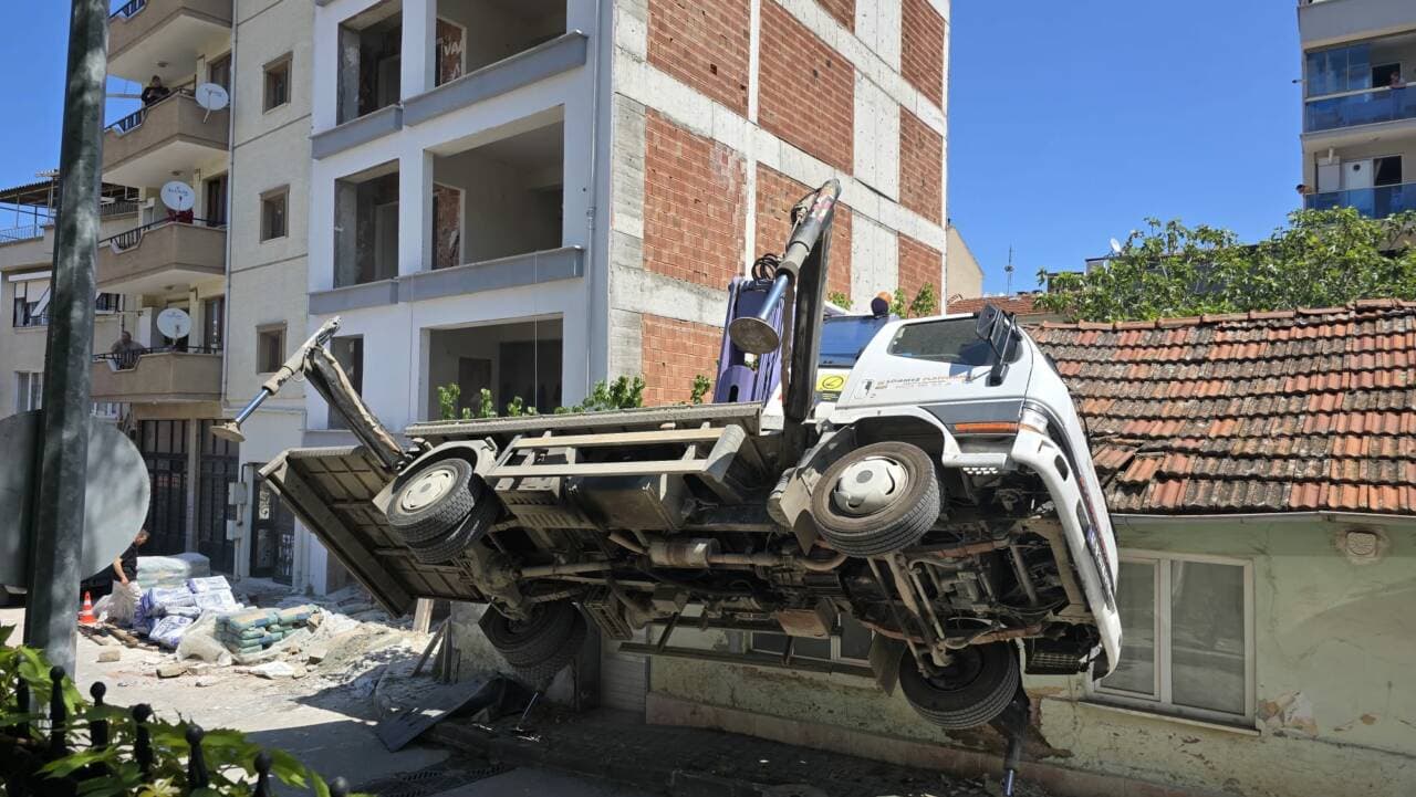 Bursa'da inşaat vincinin devrildiği kaza yerinden görüntü, hasarlı çatı ve vinç enkazı.