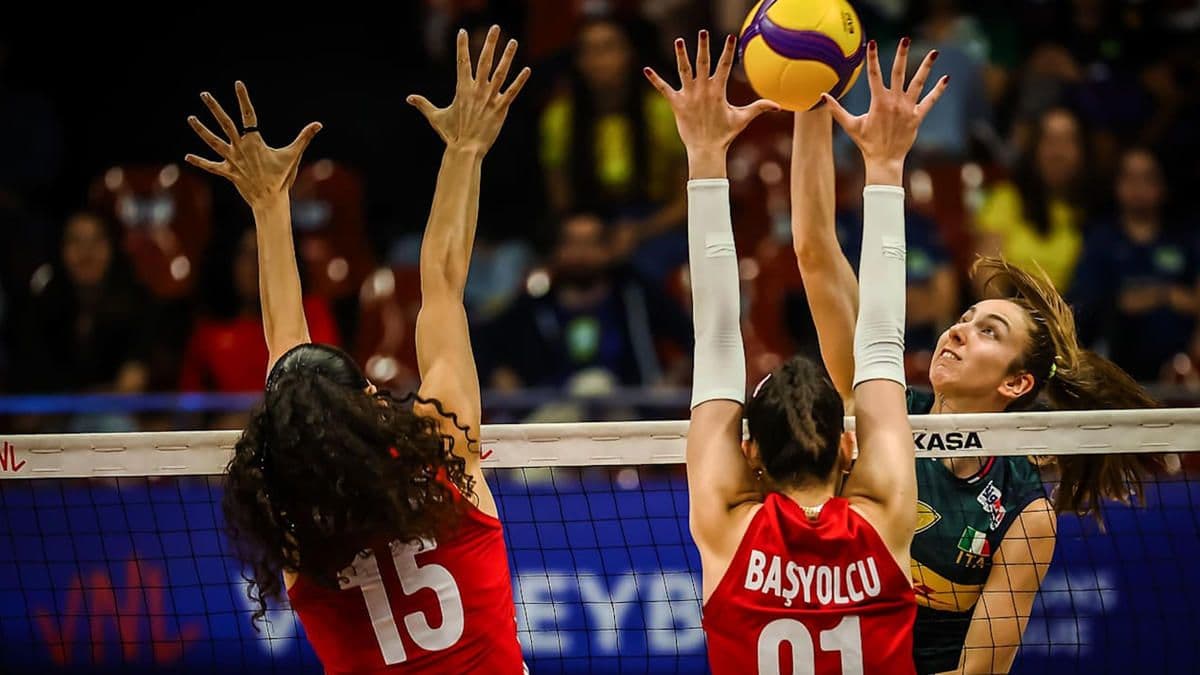 Voleybol maçında Türk ve İtalyan oyuncular file önünde topa yükseliyor.