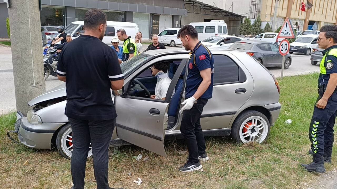 Bursa İnegöl'de elektrik direğine çarpan hasarlı otomobil ve yaralı sürücüye müdahale eden ekipler.