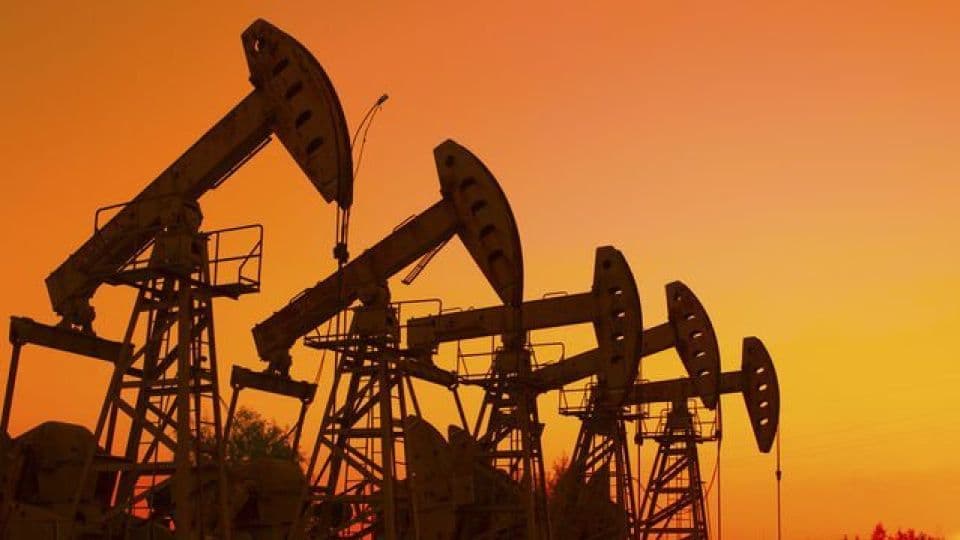 Gün batımında silüet halinde görünen petrol pompaları.