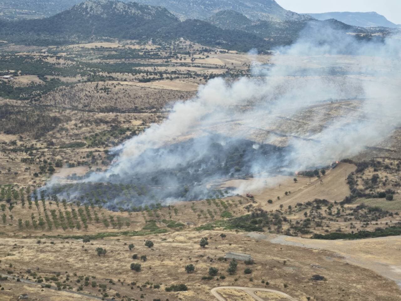 Çanakkale'nin Kiremitoba köyü yakınlarında çıkan orman yangınından yükselen yoğun dumanlar ve yanan ormanlık alan.