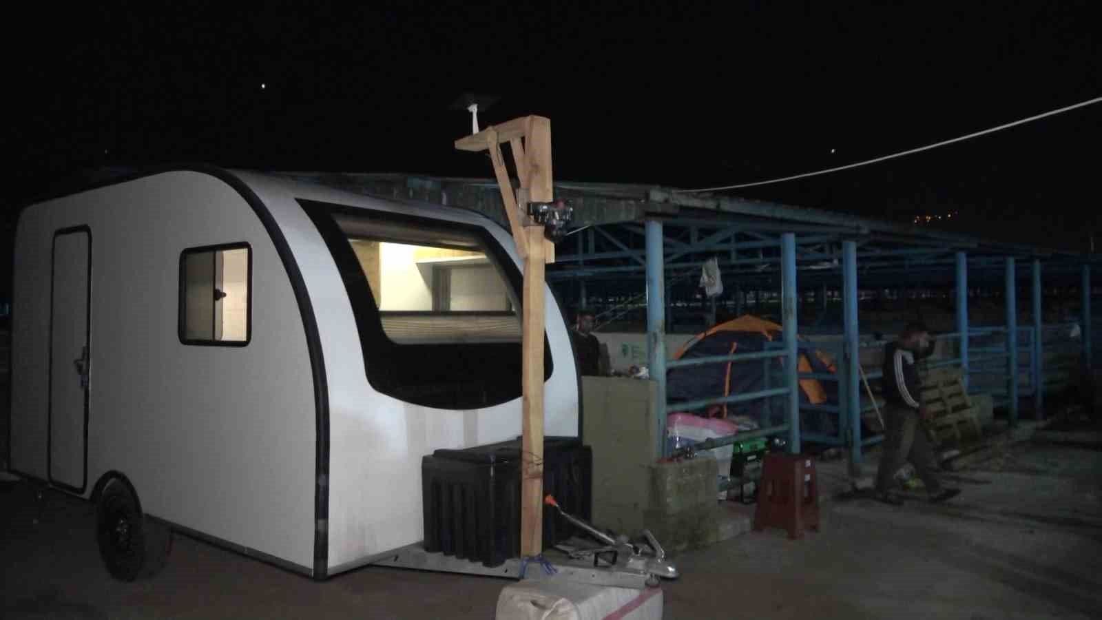 Bursa hayvan pazarında gece vakti bir karavan ve çadırların yanında duran besici.