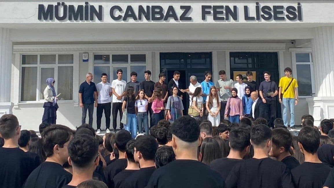 Mümin Canbaz Fen Lisesi öğrencileri ve yöneticileri okul binası önünde toplu halde.