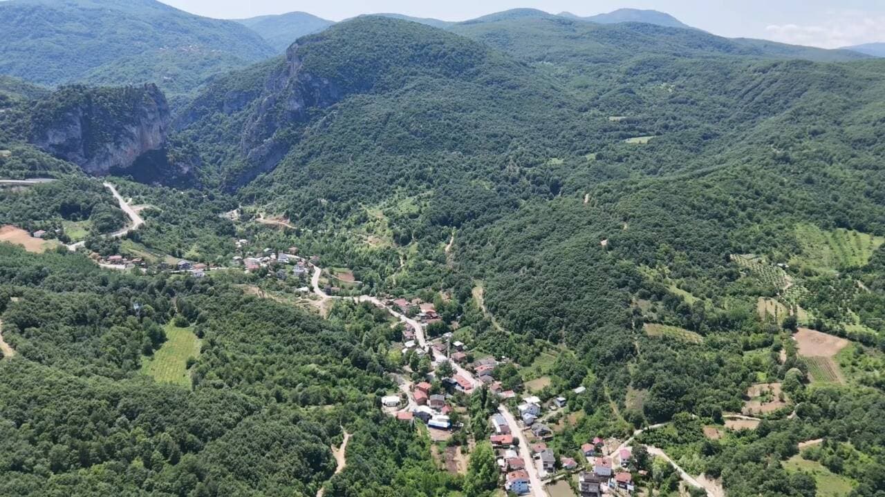 Bursa İnegöl Hilmiye Mahallesi'nin uzun yerleşim hattı ve doğal güzellikleri, havadan görünüm.