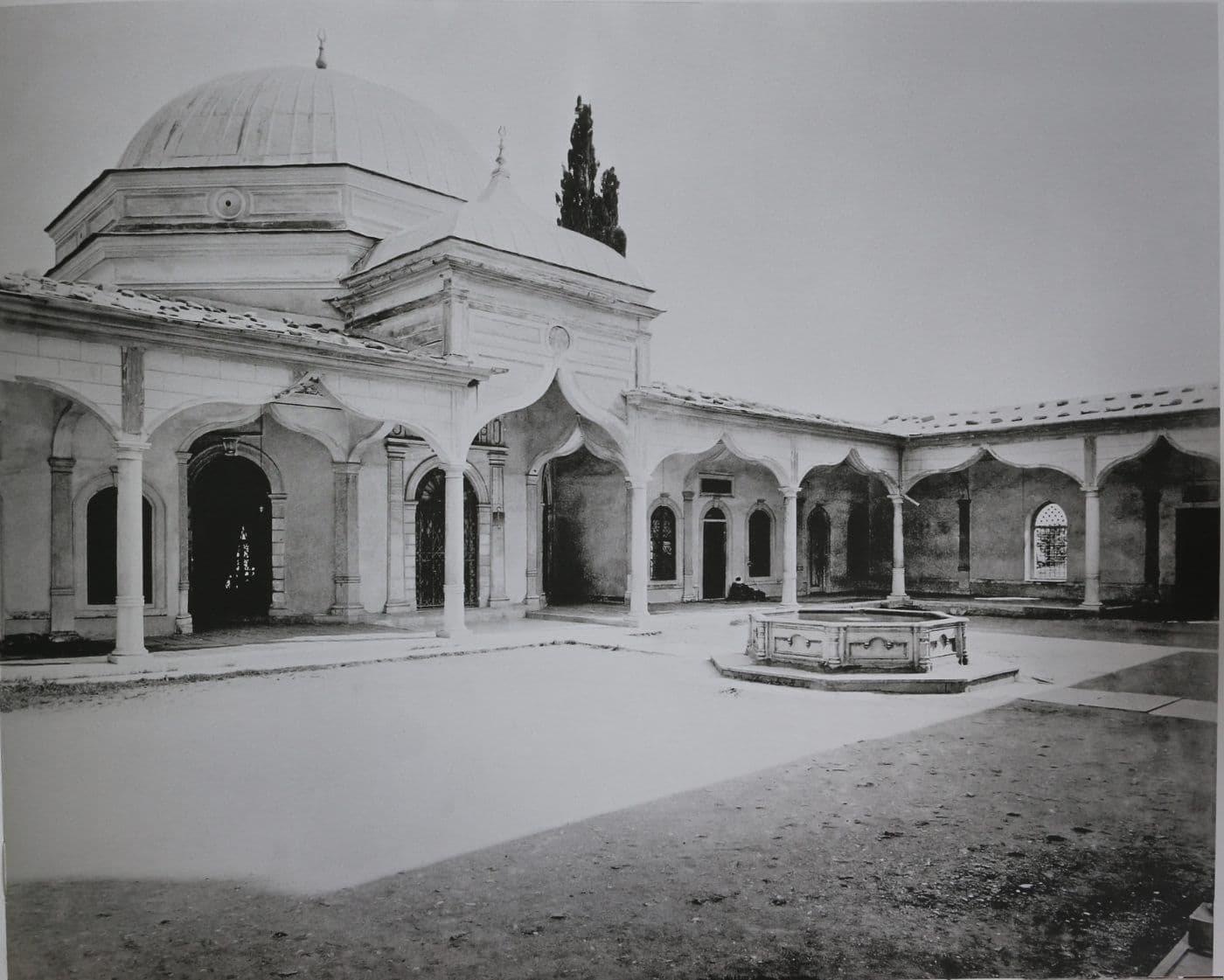 Bursa'daki tarihi Emir Sultan Camii ve Külliyesi'nin avlusundan genel görünüm. Kubbeli ana yapı, kemerli revaklar ve şadırvan.