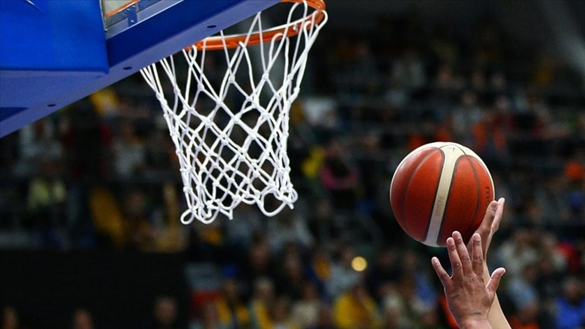 Basketbol potasına doğru atış yapan bir oyuncunun elleri ve top.