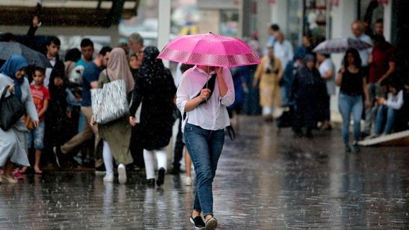Bursa'da yağmurlu havada şemsiyelerle yürüyen insanlar