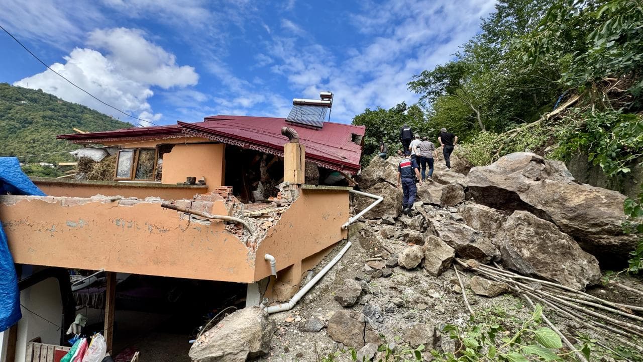 Trabzon'da heyelan sonrası hasar gören ev ve olay yerindeki ekipler.