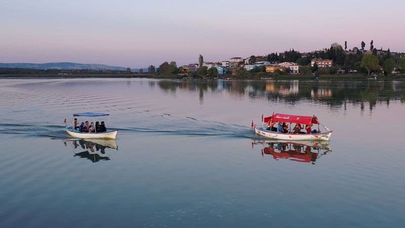 Bursa Eskikaraağaç'ta Yaren Leylek Şenliği kapsamında Uluabat Gölü'nde kayık turu yapan insanlar.