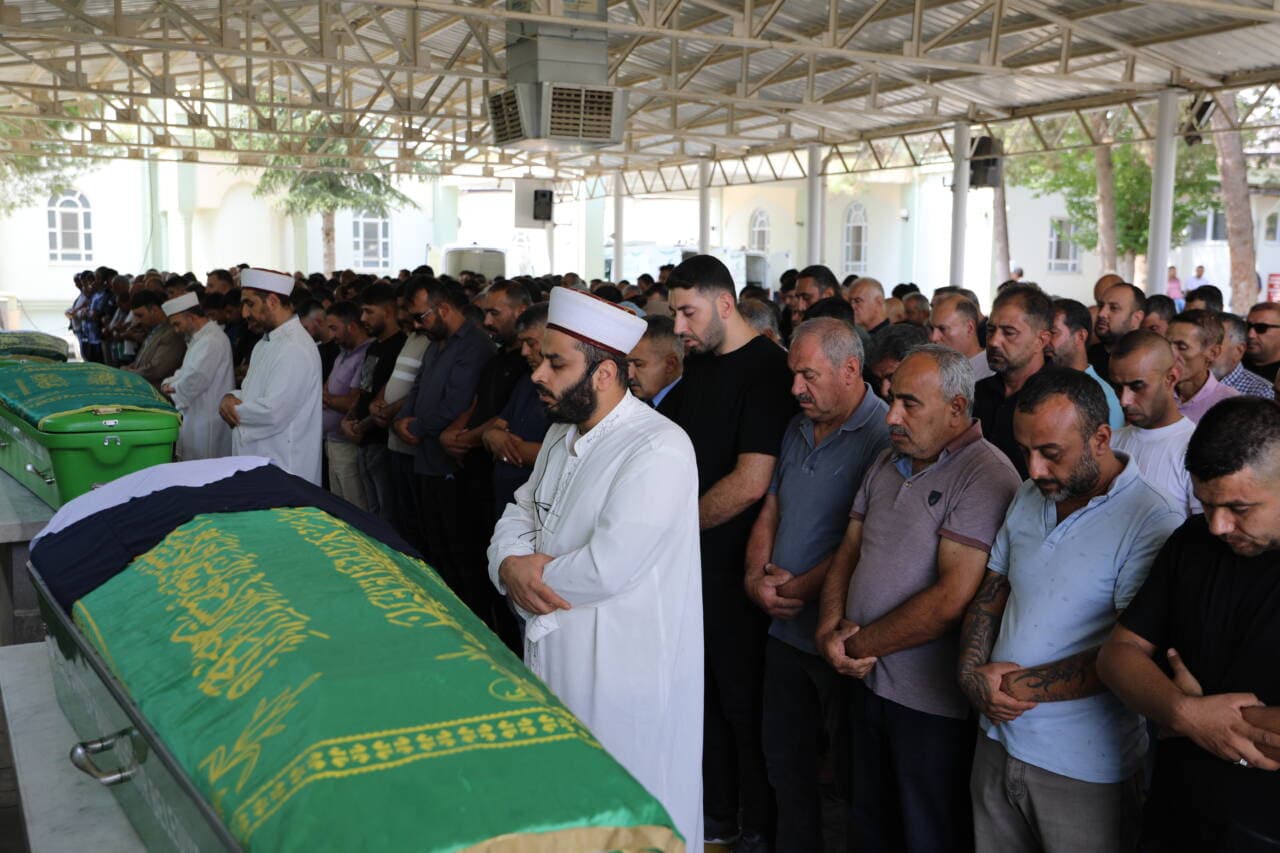 Gaziantep'te, yeşil örtülü bir tabutun etrafında cenaze namazı kılan erkekler.