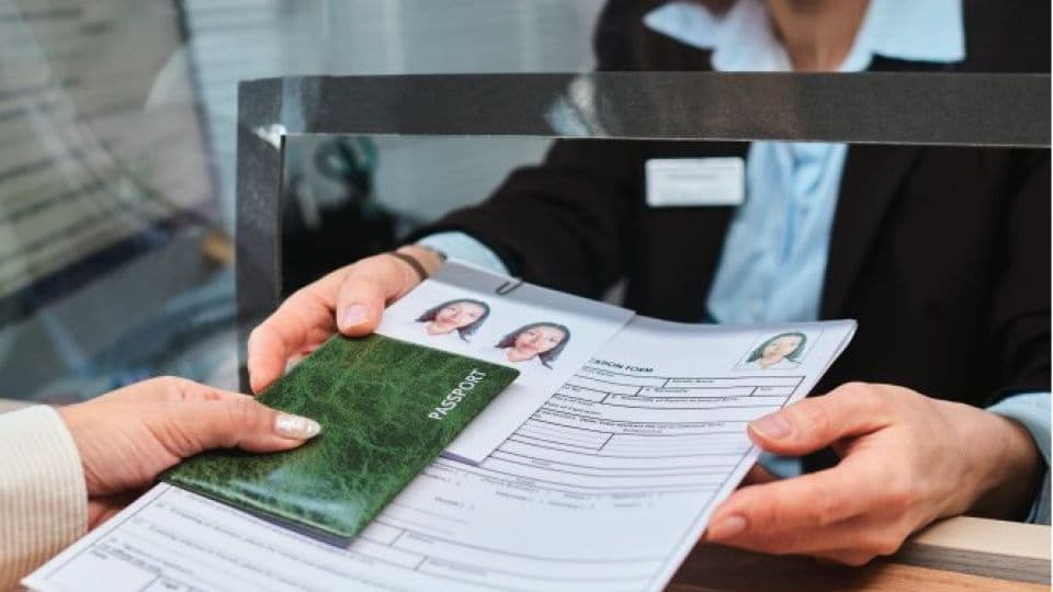 Pasaport ve vize başvuru formu uzatan eller, vize işlemleri.
