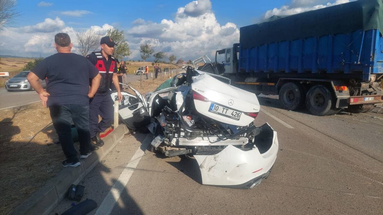 Bursa-Balıkesir yolu üzerinde meydana gelen trafik kazasında ağır hasar görmüş beyaz otomobil ve kamyon, olay yerinde polis ekipleri.