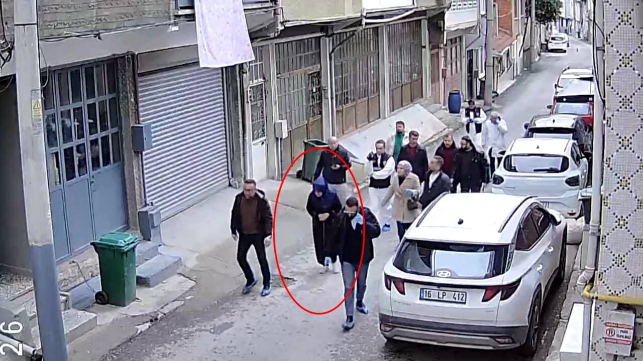 Bursa'da eş cinayeti zanlısı Adalet Uzunoğlu'nun olay yerinde polis eşliğinde keşif yaparken çekilmiş güvenlik kamerası görüntüsü.