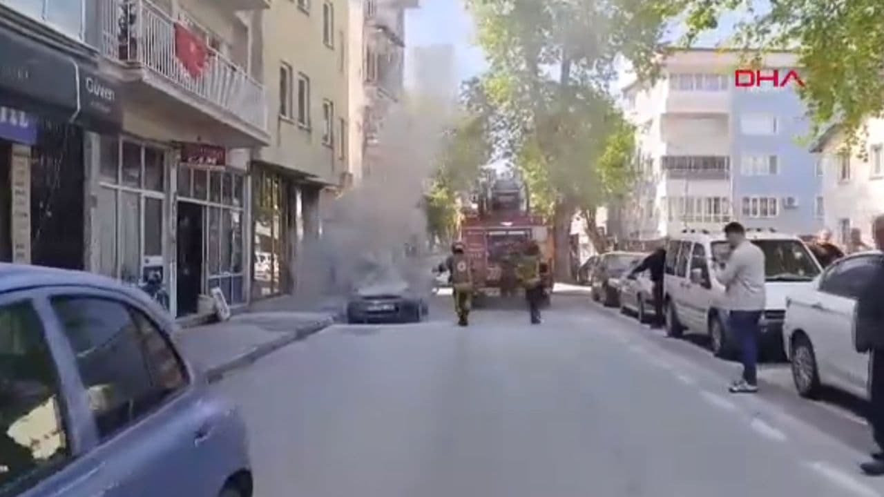 Bursa'da park halindeyken yanan otomobil ve itfaiye ekipleri.