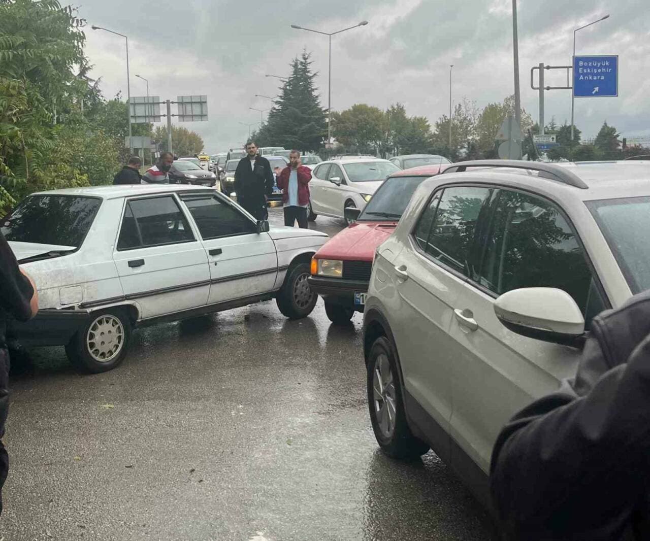 İnegöl'de meydana gelen zincirleme trafik kazasında hasar görmüş araçlar ve olay yerindeki kişiler.