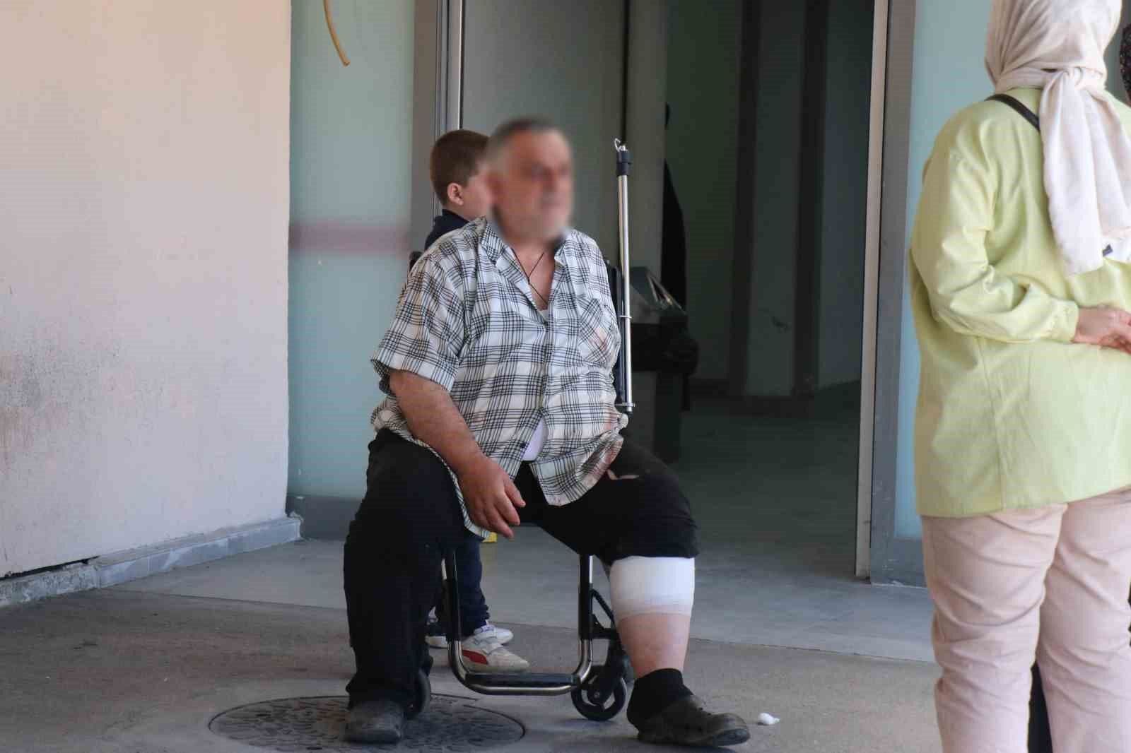 Kurban Bayramı'nda yaralanan ve bacağı sargılı bir vatandaş hastane önünde tekerlekli sandalyede bekliyor.