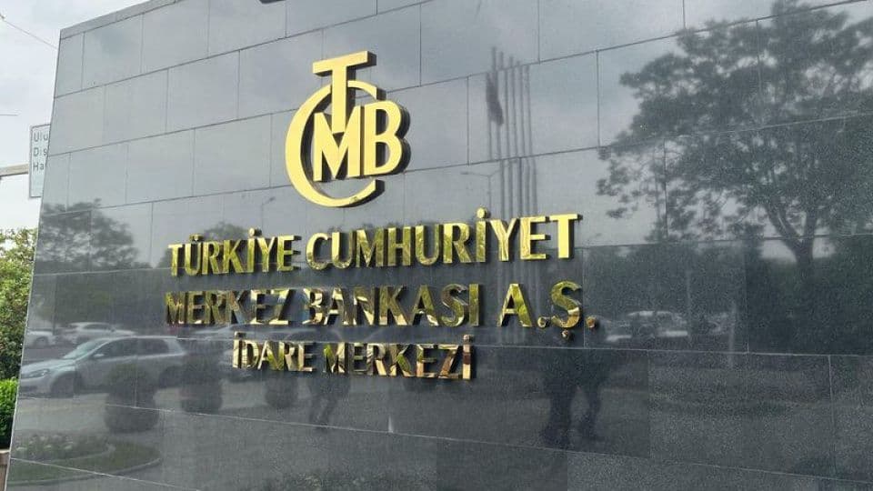 Türkiye Cumhuriyet Merkez Bankası (TCMB) binasının dış cephesi ve altın rengi logosu.