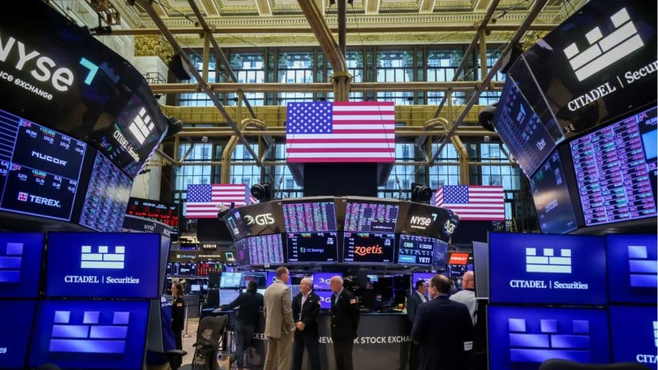 New York Borsası (NYSE) işlem katı, borsa verilerini gösteren ekranlar ve hareketli bir işlem günü.
