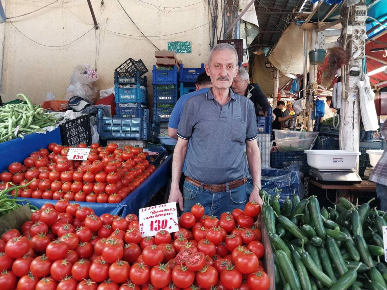 Bursa pazarında domates tezgahının önünde duran pazarcı esnafı Nedim Sarıkaya.