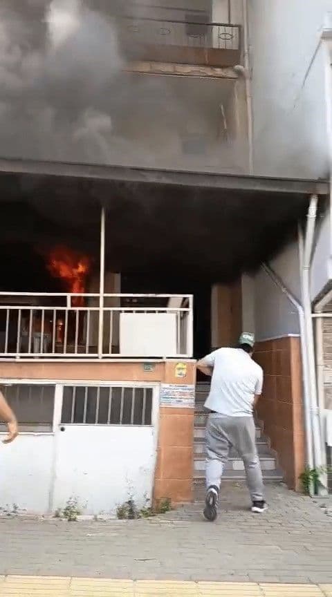 Bursa Osmangazi'de bir apartmanın giriş katında çıkan yangın, dumanlar yükseliyor.
