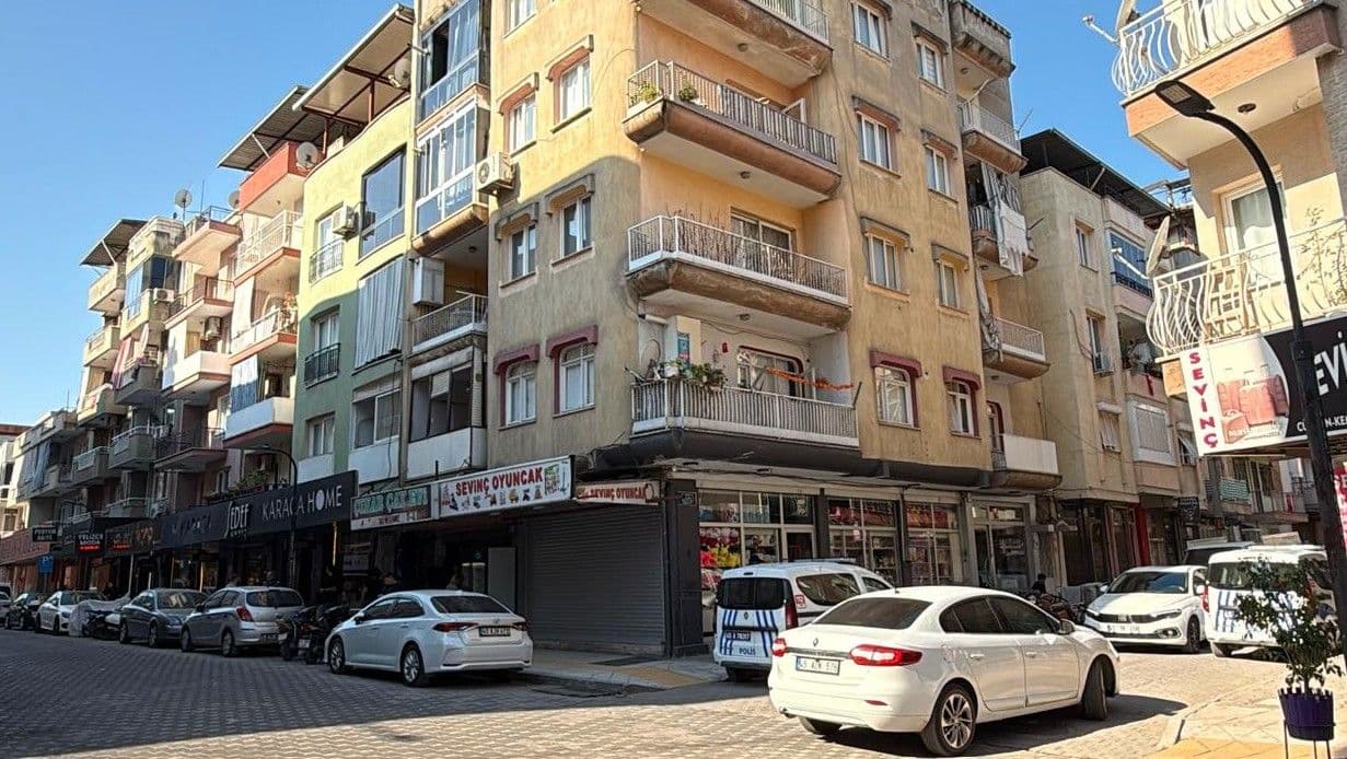 Manisa Turgutlu'da kadın cinayeti olay yerinde polis aracı ve apartmanlar.