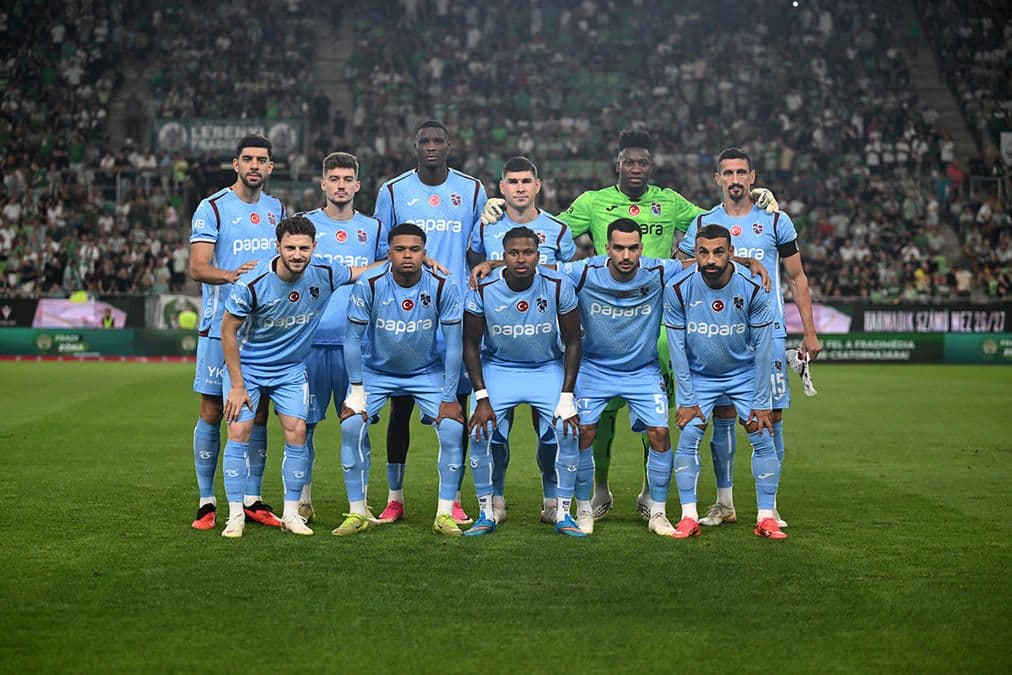 Trabzonspor futbol takımı oyuncuları sahada toplu halde poz veriyor.